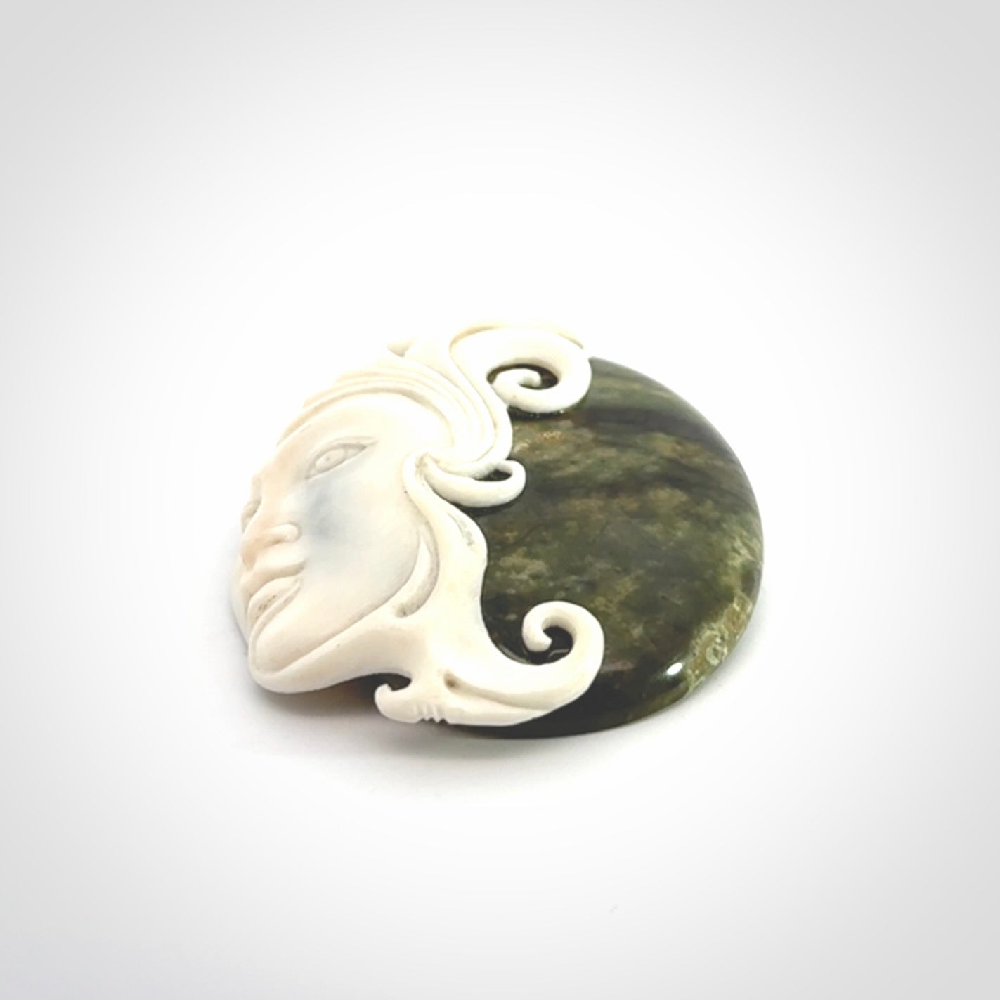 A Jade pendant with bone face. Hand carved Jade and Bone art to wear. One only.