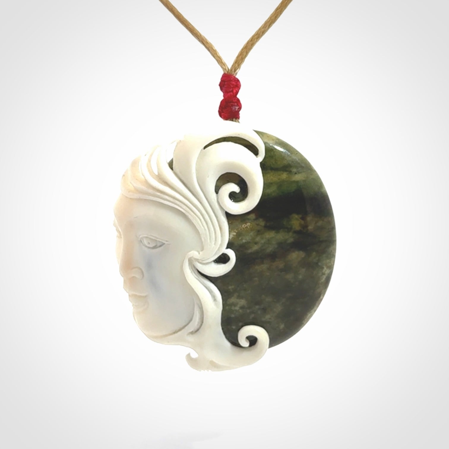 A Jade pendant with bone face. Hand carved Jade and Bone art to wear. One only.