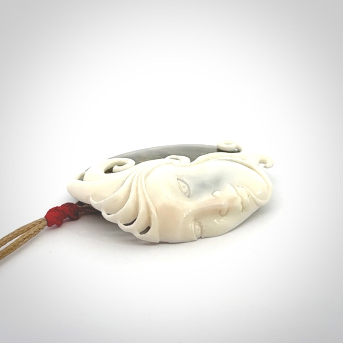 A Jade pendant with bone face. Hand carved Jade and Bone art to wear. One only.