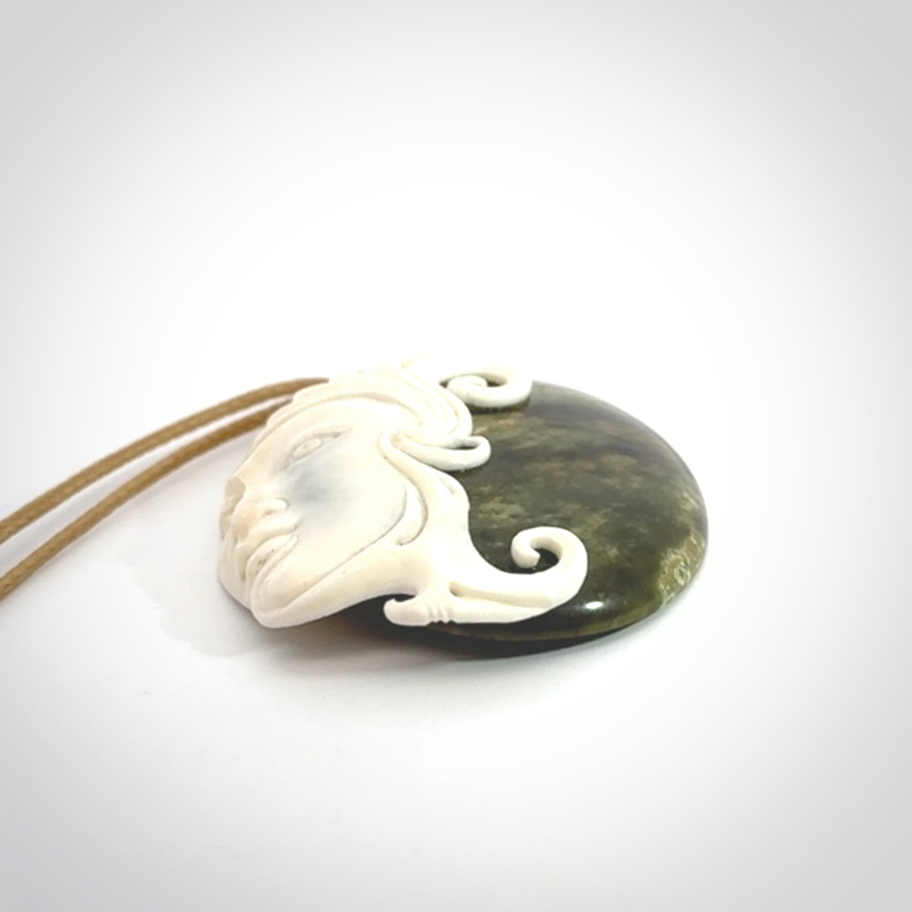 A Jade pendant with bone face. Hand carved Jade and Bone art to wear. One only.