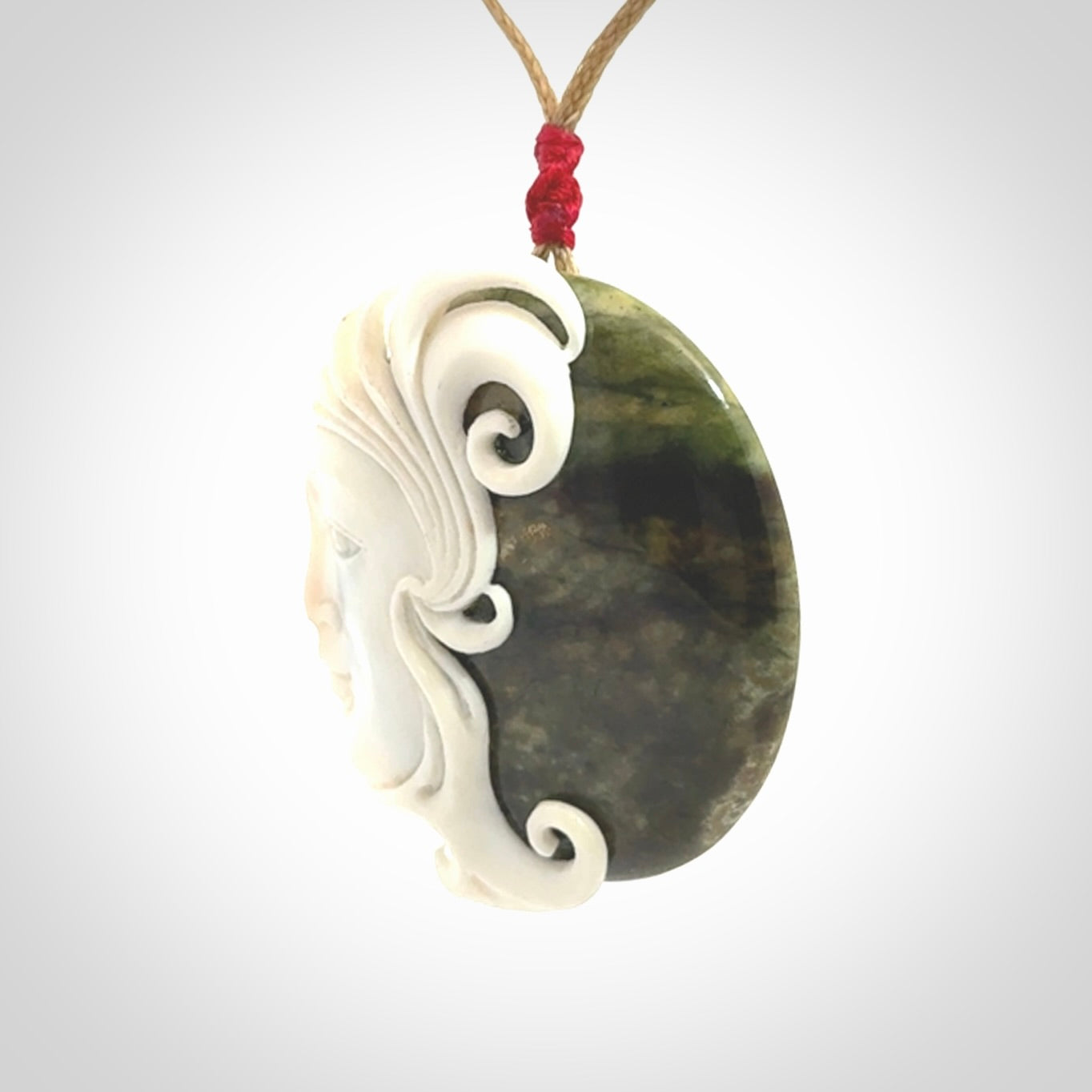 A Jade pendant with bone face. Hand carved Jade and Bone art to wear. One only.