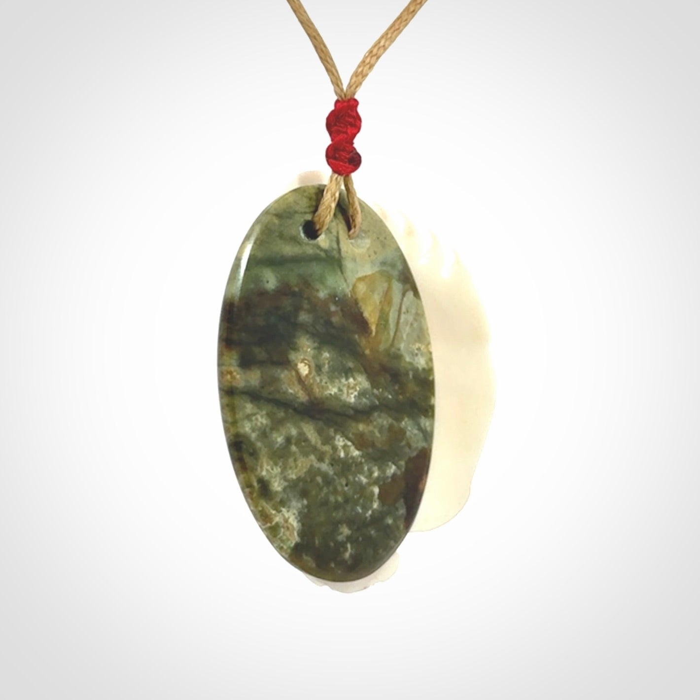 A Jade pendant with bone face. Hand carved Jade and Bone art to wear. One only.