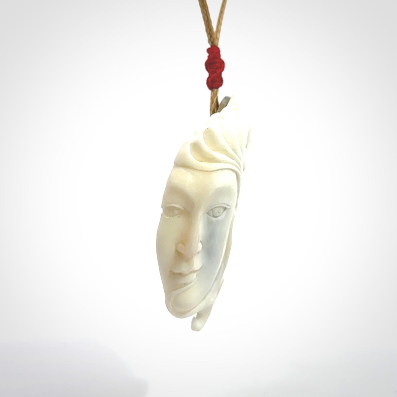 A Jade pendant with bone face. Hand carved Jade and Bone art to wear. One only.