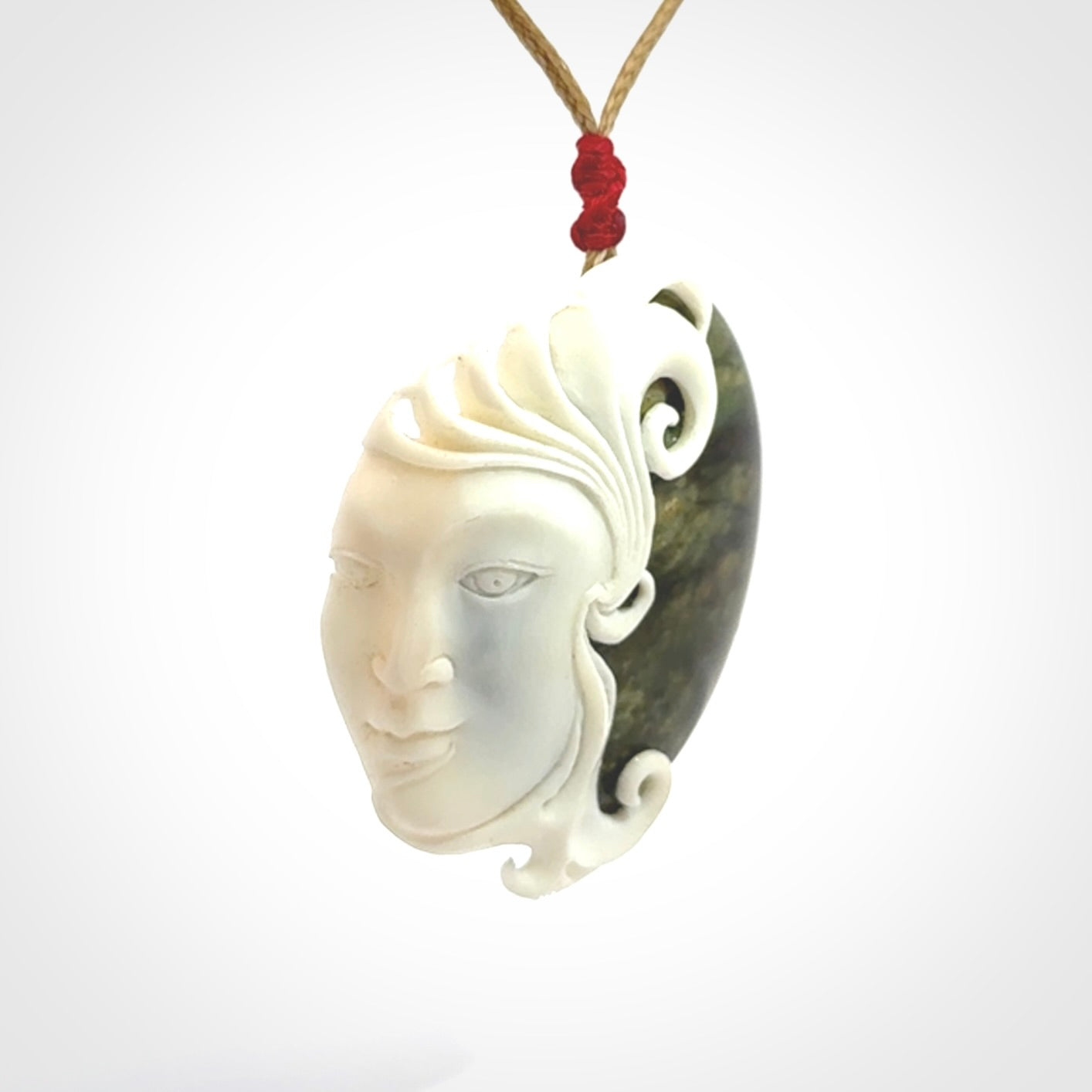 A Jade pendant with bone face. Hand carved Jade and Bone art to wear. One only.