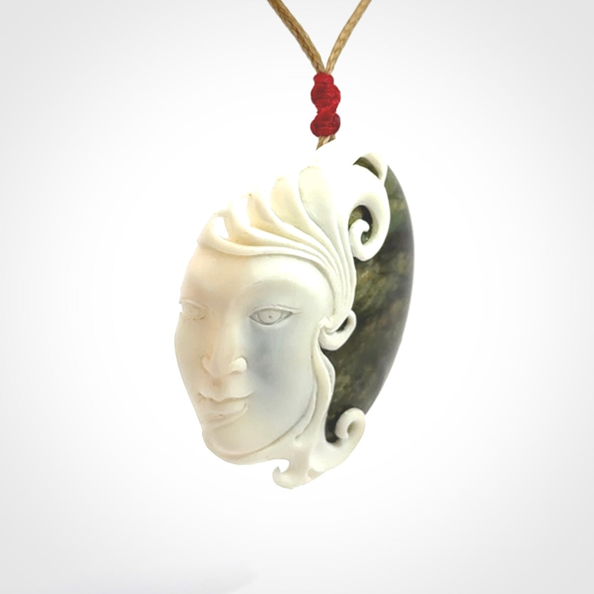 A Jade pendant with bone face. Hand carved Jade and Bone art to wear. One only.