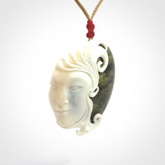 A Jade pendant with bone face. Hand carved Jade and Bone art to wear. One only.