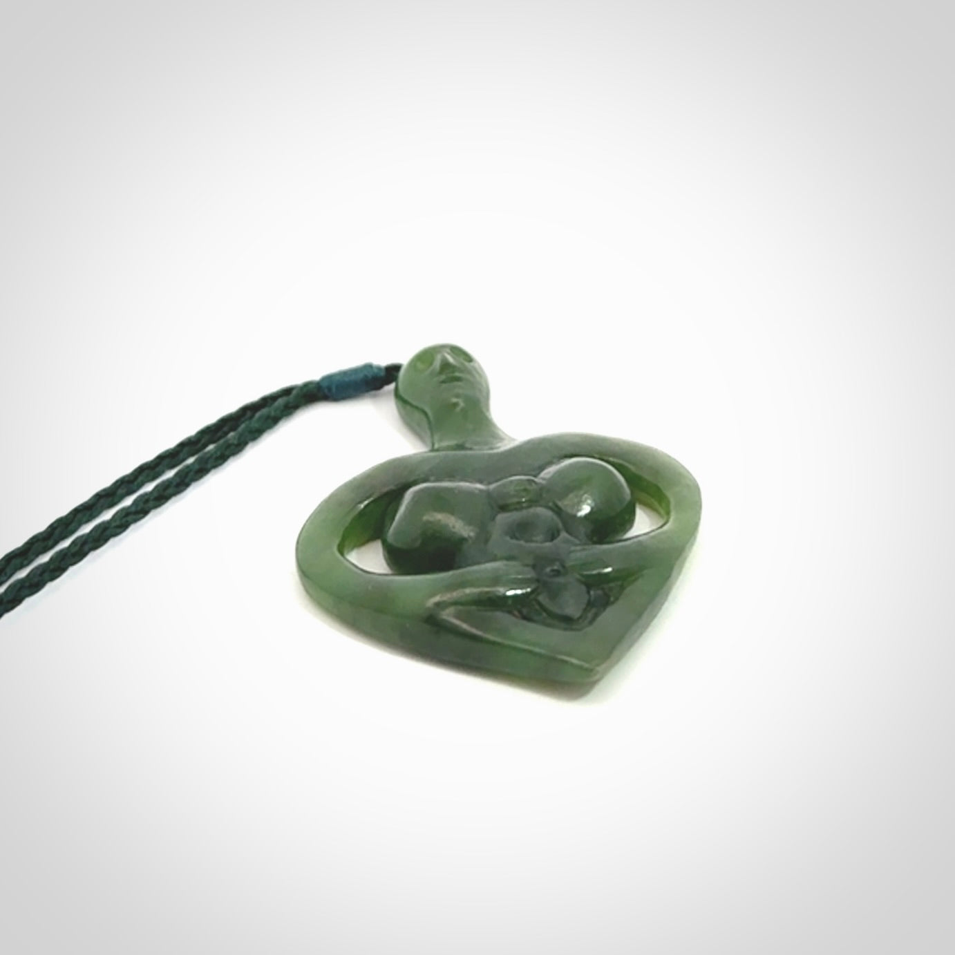 Hand carved Jade heart with mother embracing baby pendant. Contemporary design is jade. Provided with adjustable cord.