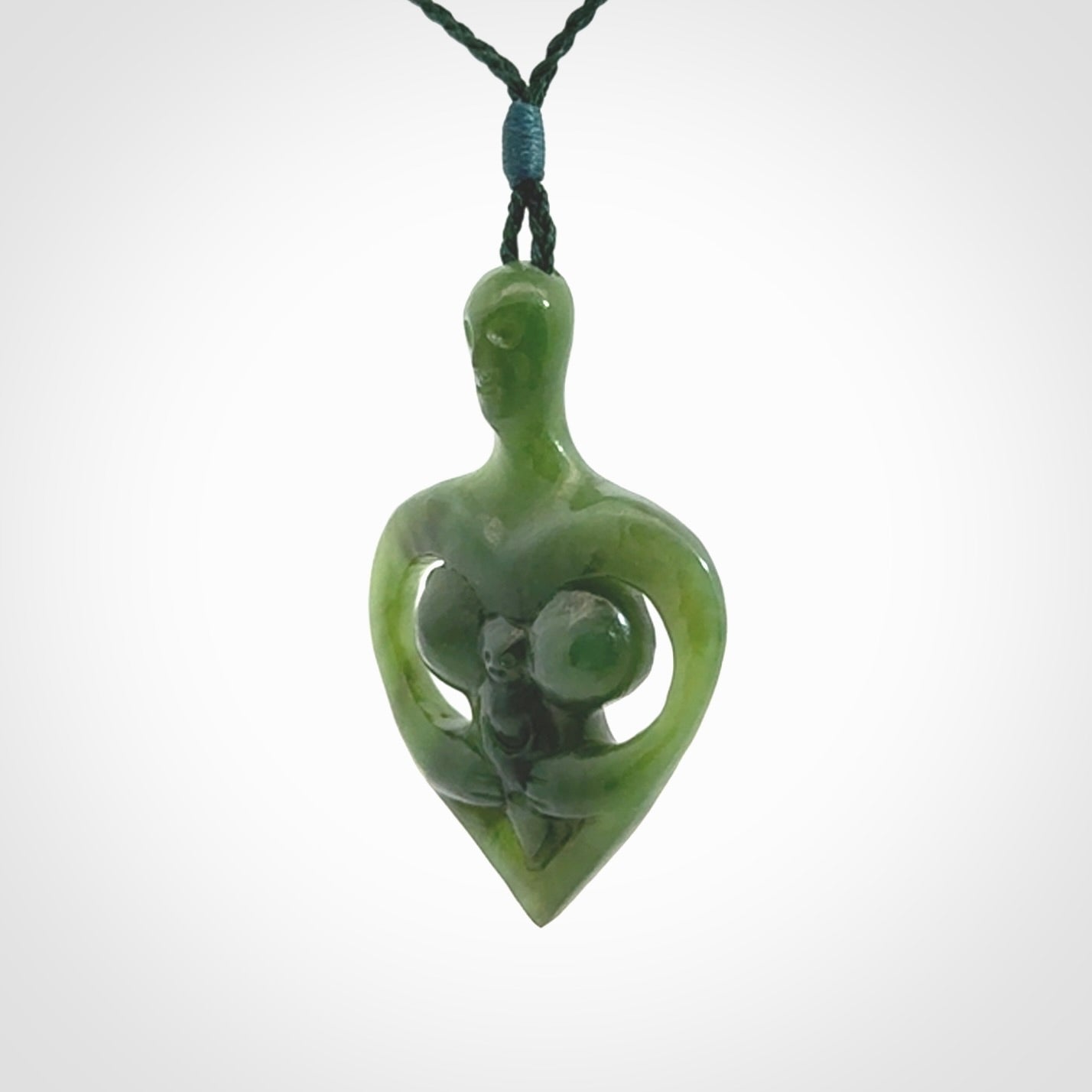 Hand carved Jade heart with mother embracing baby pendant. Contemporary design is jade. Provided with adjustable cord.