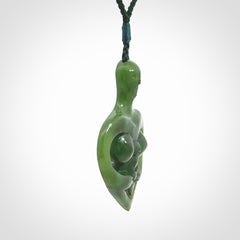 Hand carved Jade heart with mother embracing baby pendant. Contemporary design is jade. Provided with adjustable cord.
