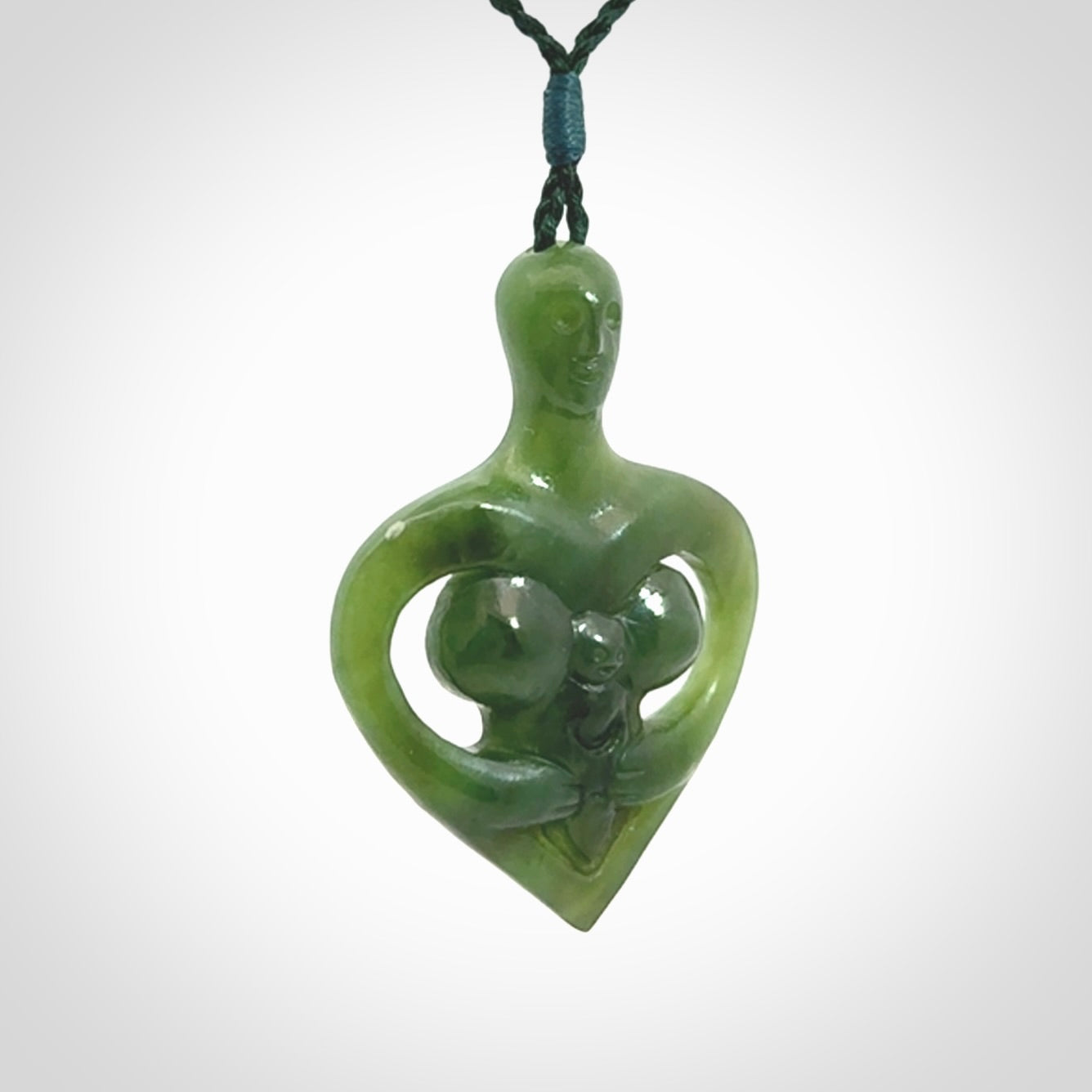 Hand carved Jade heart with mother embracing baby pendant. Contemporary design is jade. Provided with adjustable cord.
