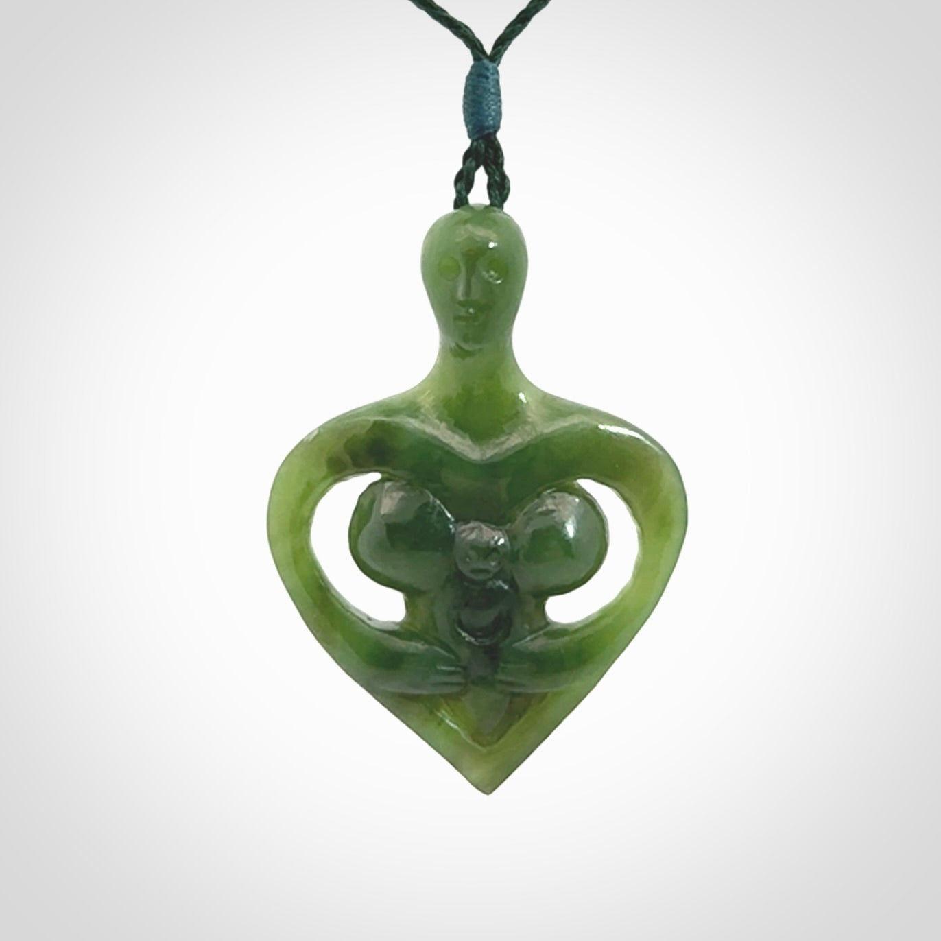 Hand carved Jade heart with mother embracing baby pendant. Contemporary design is jade. Provided with adjustable cord.
