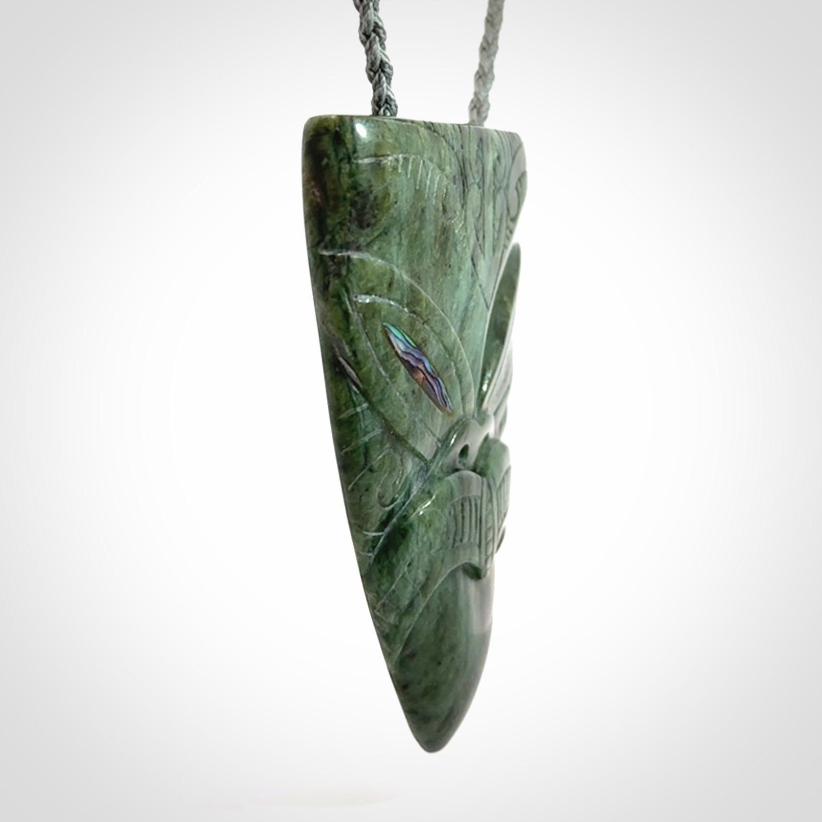 Hand carved New Zealand Jade wheku pendant with paua shell eyes