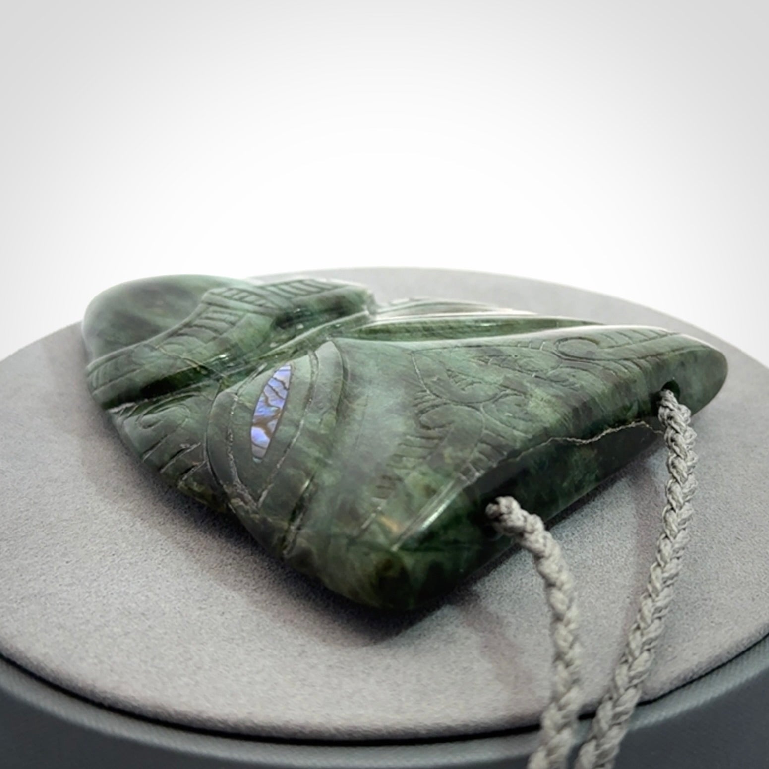 Hand carved New Zealand Jade wheku pendant with paua shell eyes