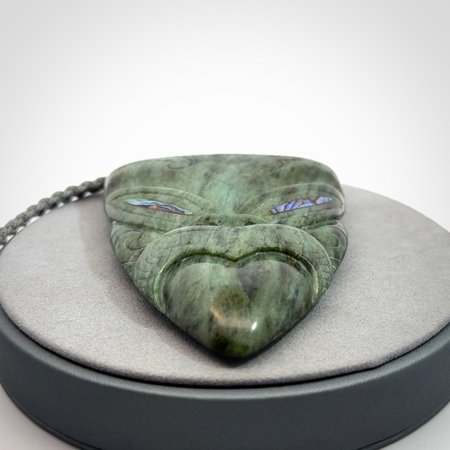 Hand carved New Zealand Jade wheku pendant with paua shell eyes