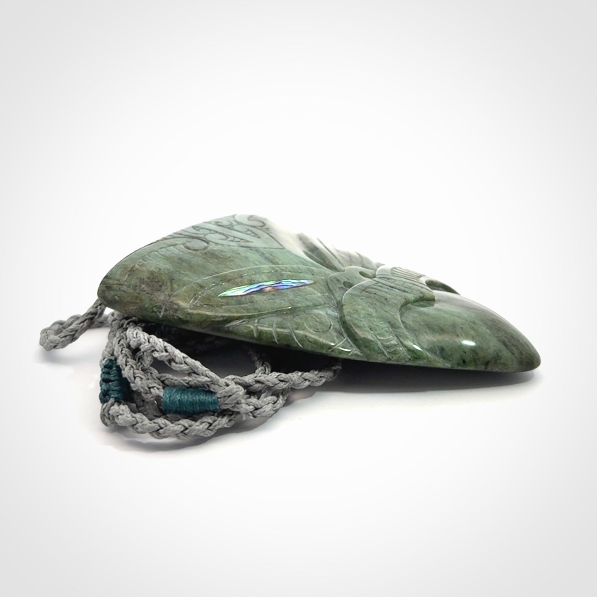Hand carved New Zealand Jade wheku pendant with paua shell eyes