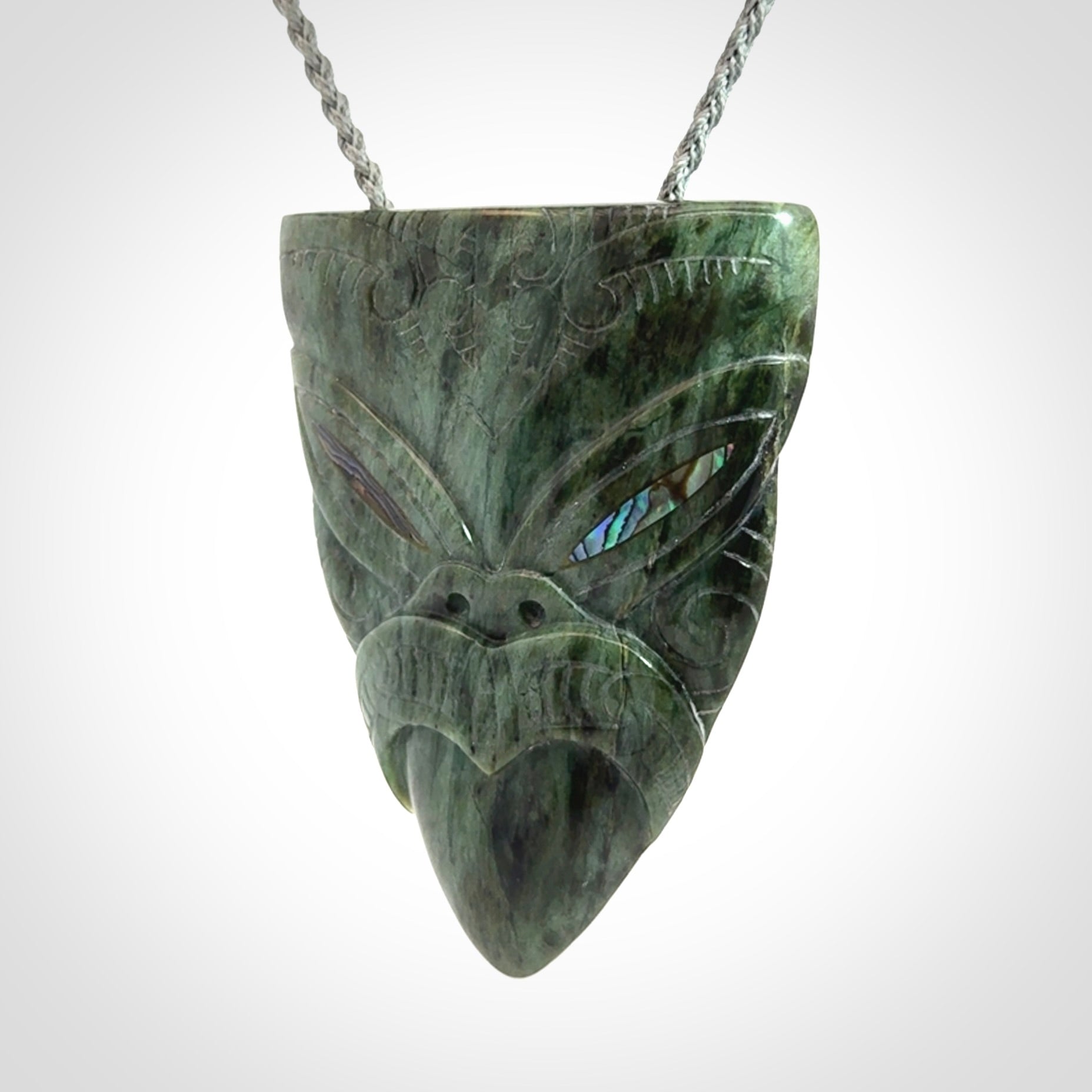 Hand carved New Zealand Jade wheku pendant with paua shell eyes
