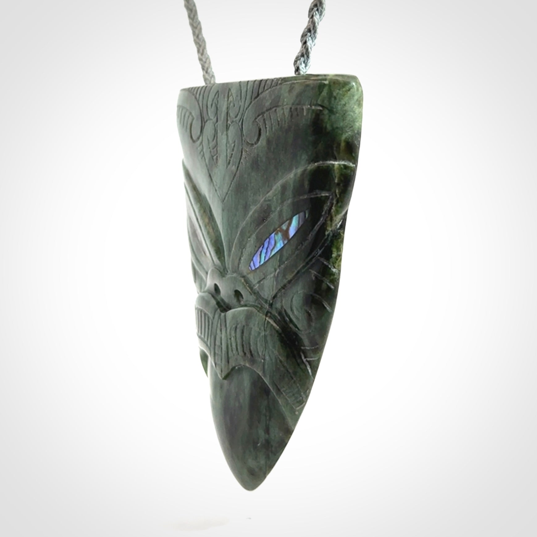 Hand carved New Zealand Jade wheku pendant with paua shell eyes