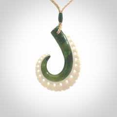 This photo shows a beautiful jade hook with bone pendant. It is handcarved from a piece of mottled green Jade, with fascinating mauve tinges through the stone. We have this on a adjustable cord. We ship this worldwide with an express courier service. Postage is free.