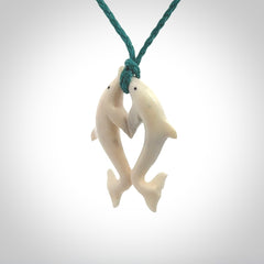 Hand carved natural double dolphin bone pendant. Hand made bone dolphin necklace, delivered with Express Courier. Hand crafted bone double dolphin pendant. Provided with an adjustable blue cord.