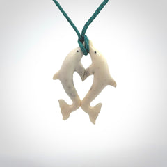 Hand carved natural double dolphin bone pendant. Hand made bone dolphin necklace, delivered with Express Courier. Hand crafted bone double dolphin pendant. Provided with an adjustable blue cord.