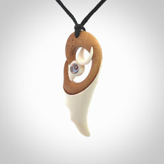 A hand carved bone contemporary bird pendant. The cord is a black colour and is a fixed length. A medium sized hand made contemporary necklace by New Zealand artist Kerry Thompson. Kerry has stained parts of the bone which really add to the dimension of this pendant. One off work of art to wear.