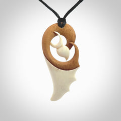 A hand carved bone contemporary bird pendant. The cord is a black colour and is a fixed length. A medium sized hand made contemporary necklace by New Zealand artist Kerry Thompson. Kerry has stained parts of the bone which really add to the dimension of this pendant. One off work of art to wear.