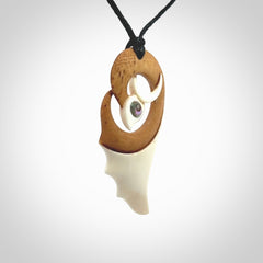 A hand carved bone contemporary bird pendant. The cord is a black colour and is a fixed length. A medium sized hand made contemporary necklace by New Zealand artist Kerry Thompson. Kerry has stained parts of the bone which really add to the dimension of this pendant. One off work of art to wear.