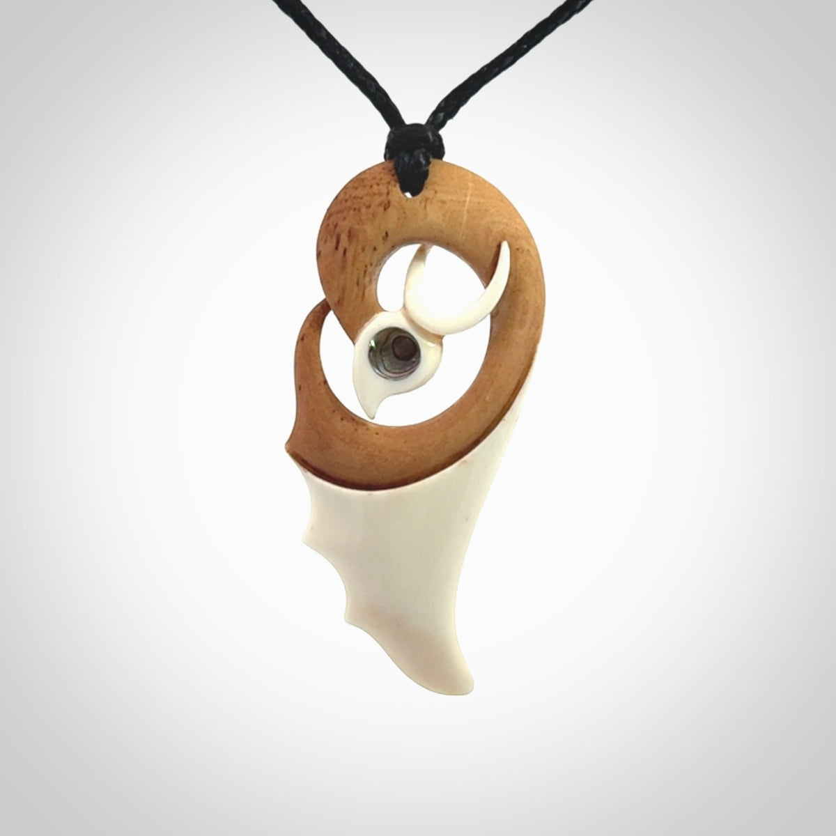A hand carved bone contemporary bird pendant. The cord is a black colour and is a fixed length. A medium sized hand made contemporary necklace by New Zealand artist Kerry Thompson. Kerry has stained parts of the bone which really add to the dimension of this pendant. One off work of art to wear.