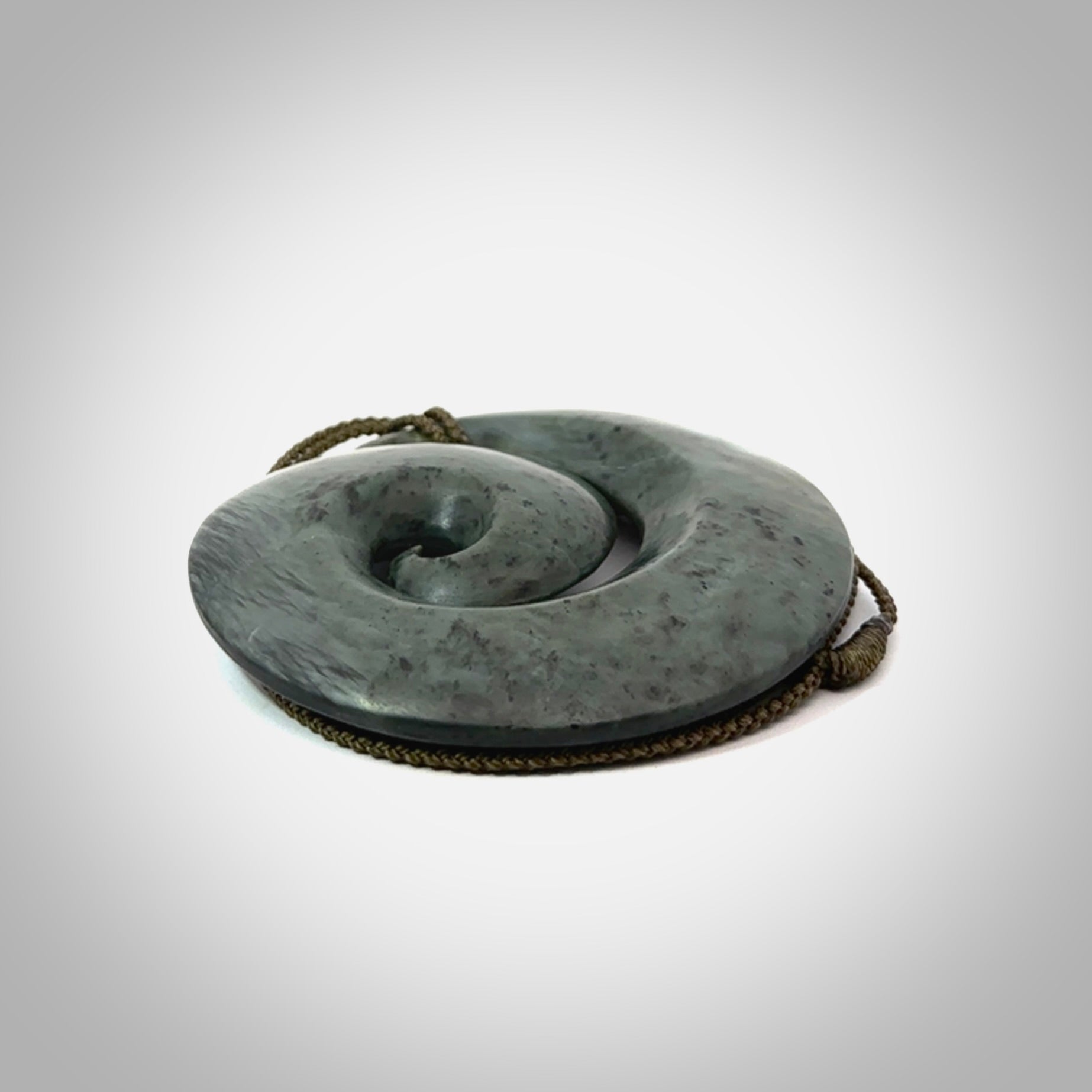 This pendant is a large sized koru necklace carved from a blue/grey piece of New Zealand Jade. Kyohei Noguchi carved this piece for us so the workmanship is outstanding. Handmade in New Zealand, a beautiful piece of jade jewellery.