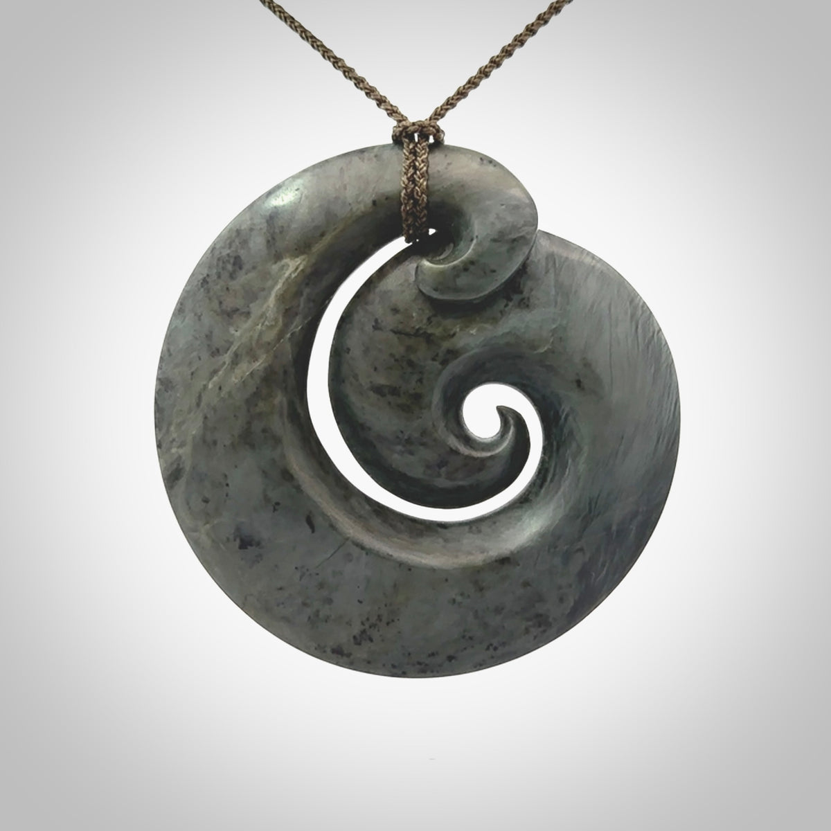 This pendant is a large sized koru necklace carved from a blue/grey piece of New Zealand Jade. Kyohei Noguchi carved this piece for us so the workmanship is outstanding. Handmade in New Zealand, a beautiful piece of jade jewellery.