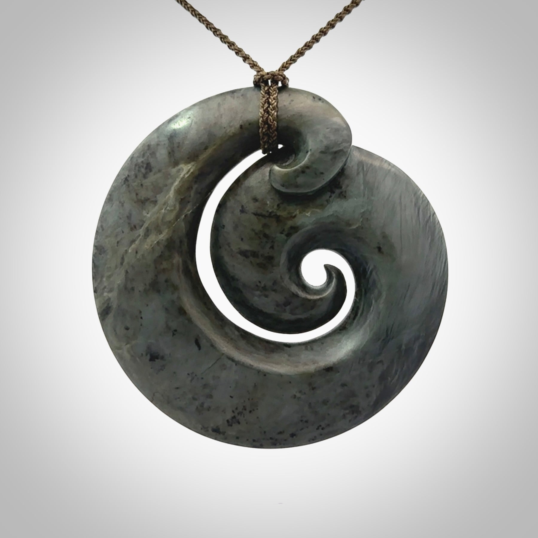 This pendant is a large sized koru necklace carved from a blue/grey piece of New Zealand Jade. Kyohei Noguchi carved this piece for us so the workmanship is outstanding. Handmade in New Zealand, a beautiful piece of jade jewellery.