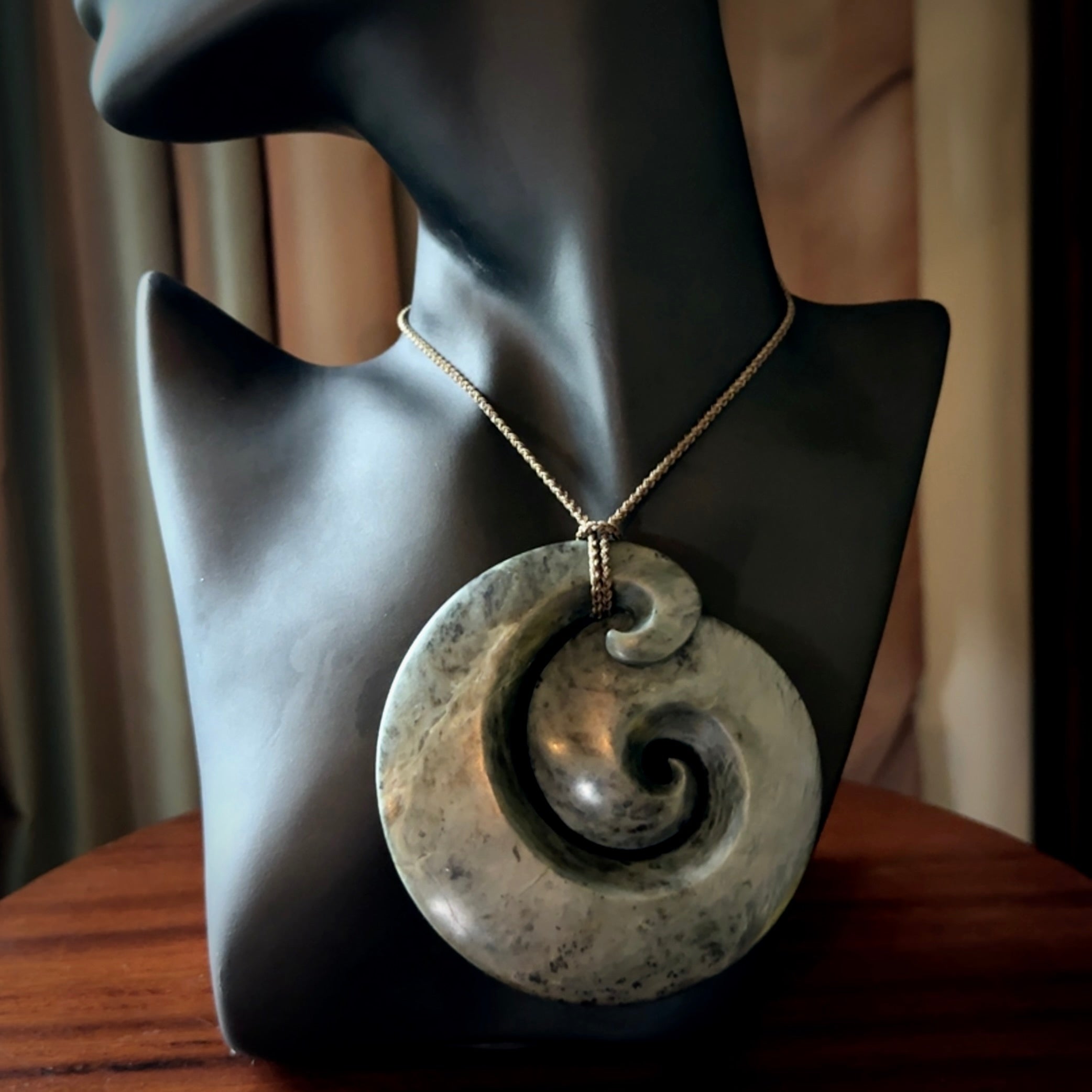 This pendant is a large sized koru necklace carved from a blue/grey piece of New Zealand Jade. Kyohei Noguchi carved this piece for us so the workmanship is outstanding. Handmade in New Zealand, a beautiful piece of jade jewellery.