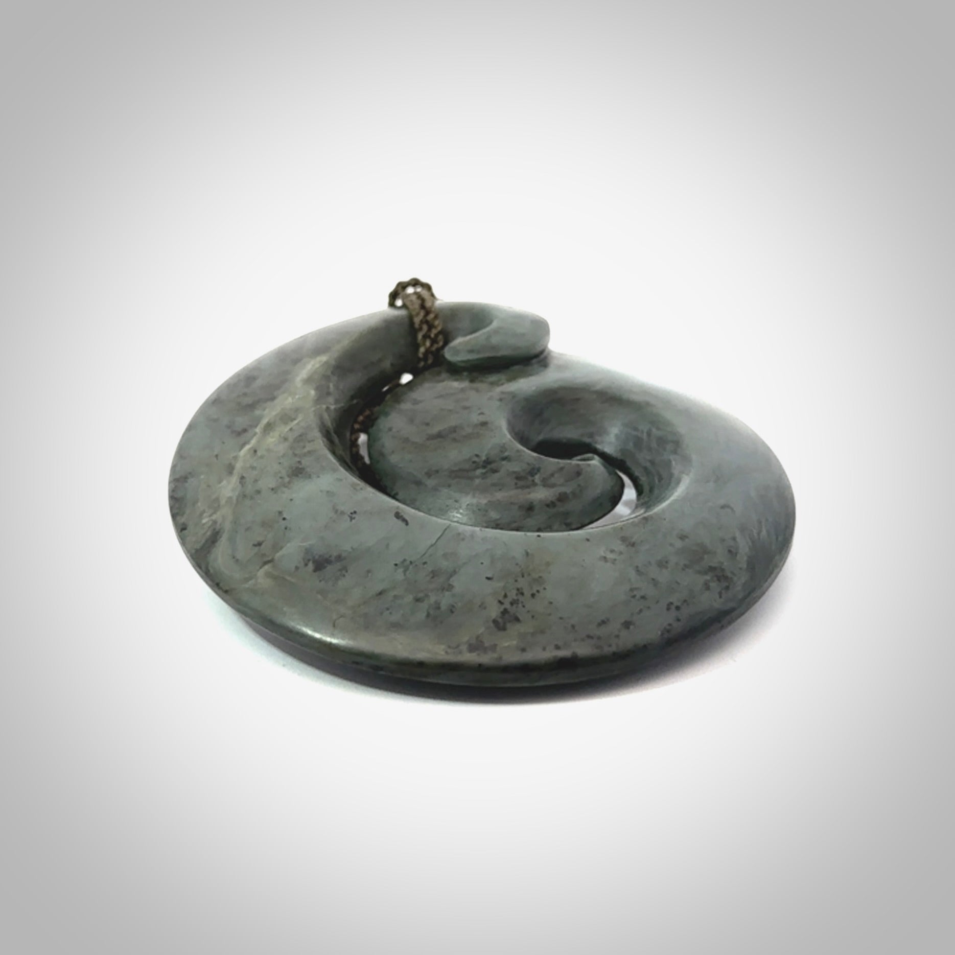 This pendant is a large sized koru necklace carved from a blue/grey piece of New Zealand Jade. Kyohei Noguchi carved this piece for us so the workmanship is outstanding. Handmade in New Zealand, a beautiful piece of jade jewellery.