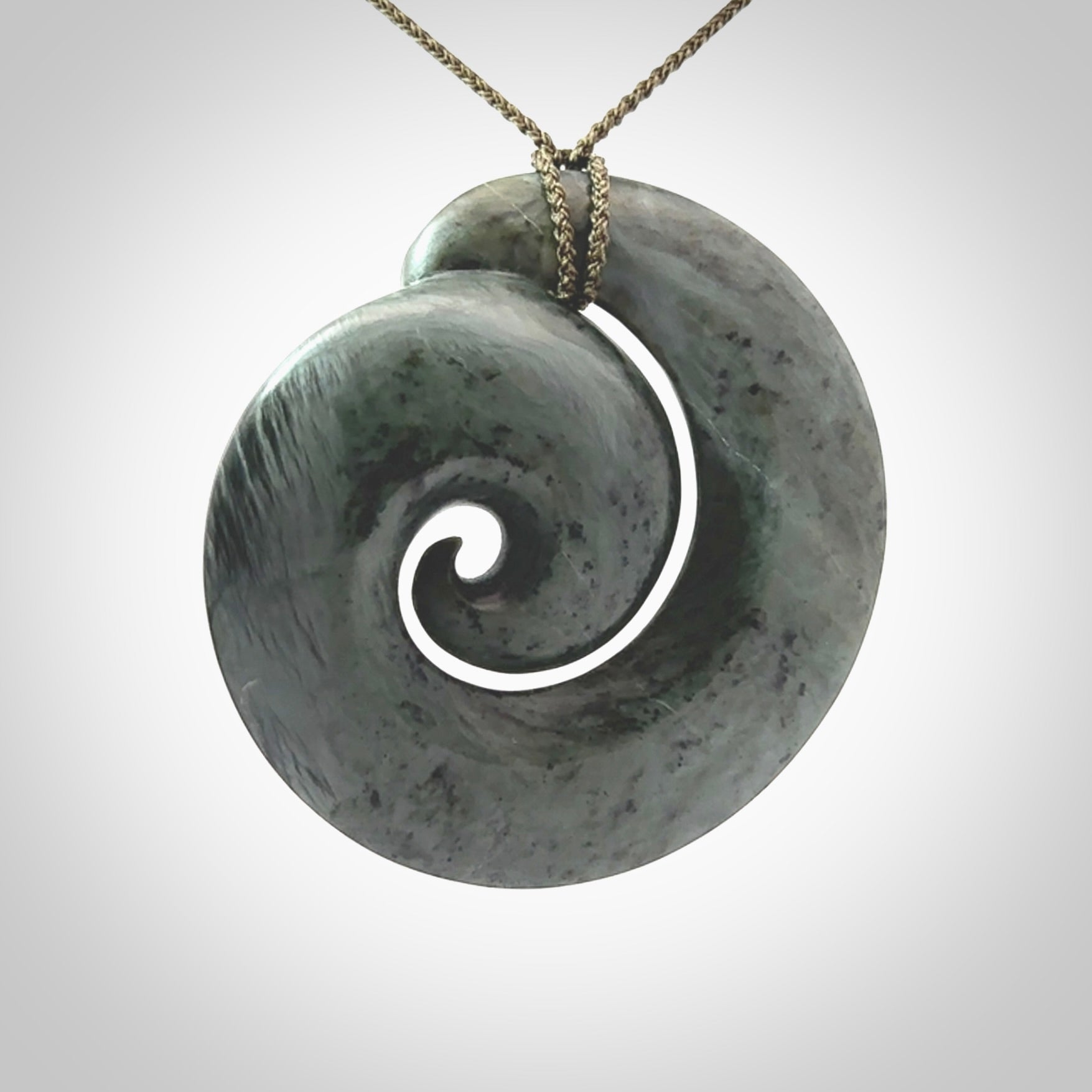 This pendant is a large sized koru necklace carved from a blue/grey piece of New Zealand Jade. Kyohei Noguchi carved this piece for us so the workmanship is outstanding. Handmade in New Zealand, a beautiful piece of jade jewellery.