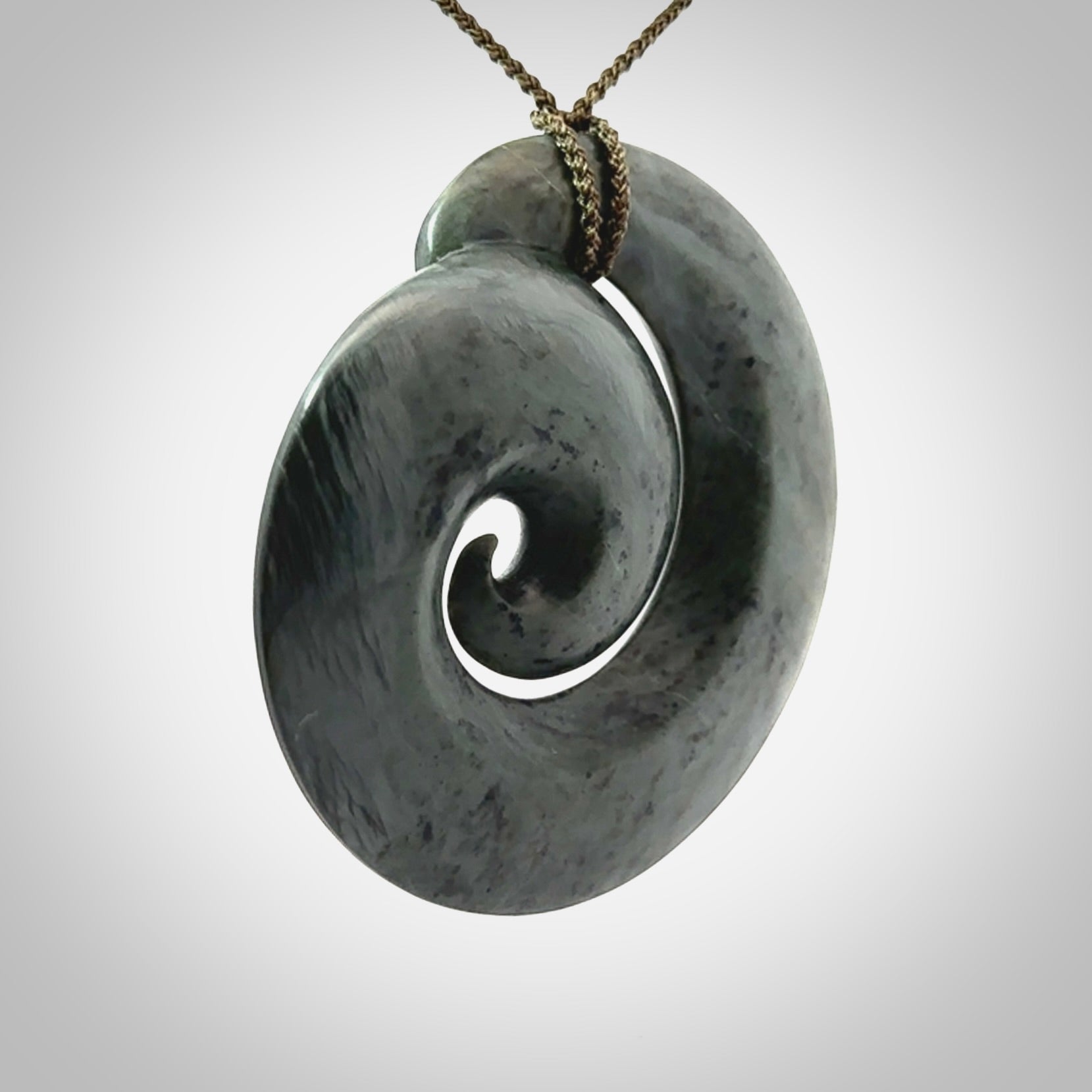 This pendant is a large sized koru necklace carved from a blue/grey piece of New Zealand Jade. Kyohei Noguchi carved this piece for us so the workmanship is outstanding. Handmade in New Zealand, a beautiful piece of jade jewellery.
