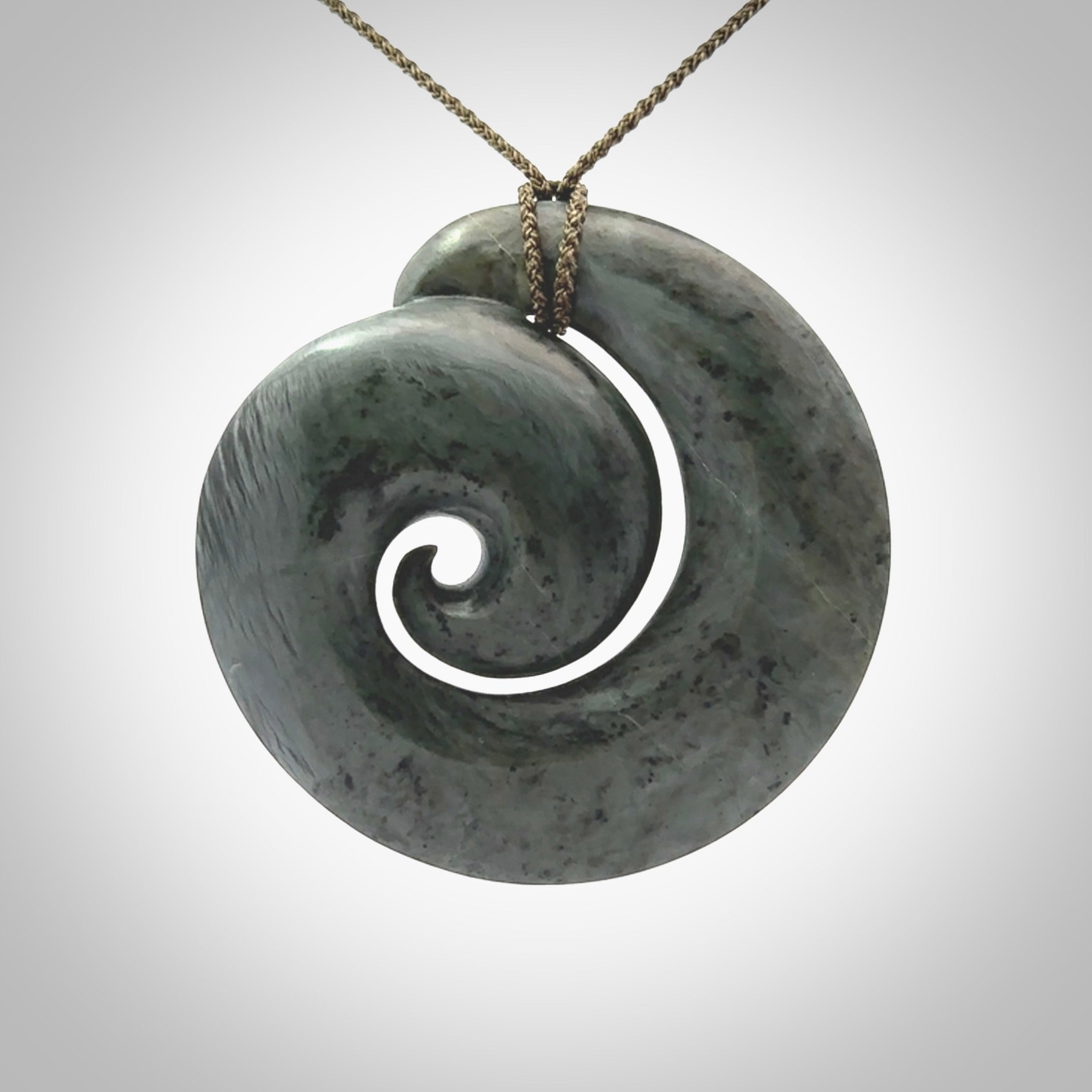 This pendant is a large sized koru necklace carved from a blue/grey piece of New Zealand Jade. Kyohei Noguchi carved this piece for us so the workmanship is outstanding. Handmade in New Zealand, a beautiful piece of jade jewellery.