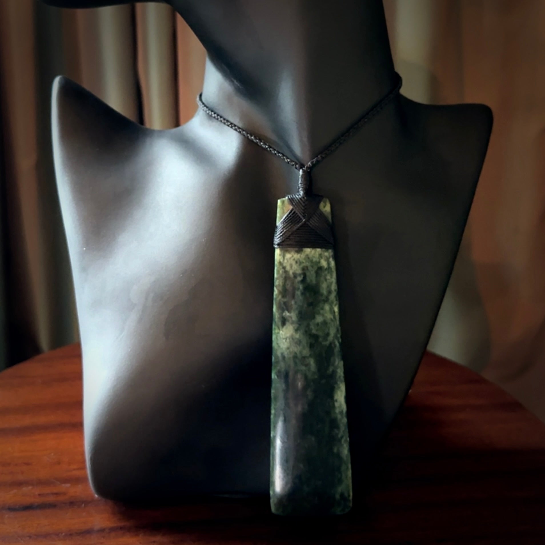 Hand carved from a lovely piece of local New Zealand Marsden Jade. The quality of the workmanship and design is outstanding - this is a piece you will want to wear all the time. We have suspended this from a 4-plait black cord which can be adjusted with a couple of slip knots and black binding. Hand made by Kyohei Noguchi.