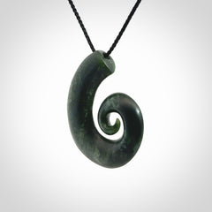 This picture shows a koru pendant, hand carved from New Zealand jade. We will provide this with an adjustable black plaited cord. This has been hand carved by Kyohei Noguchi. One only pendant, shipped to you with express courier.