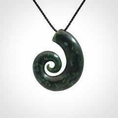 This picture shows a koru pendant, hand carved from New Zealand jade. We will provide this with an adjustable black plaited cord. This has been hand carved by Kyohei Noguchi. One only pendant, shipped to you with express courier.