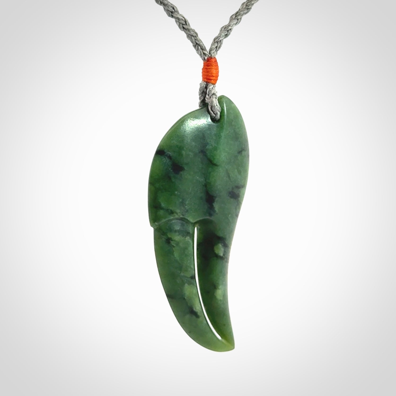 This large crab claw pendant is carved from a lovely deep green piece of New Zealand jade. It has an adjustable silver coloured cord which can be slipped over the head and adjusted to the length that you prefer. Hand carved in New Zealand from our local jade by Kyohei Noguchi.