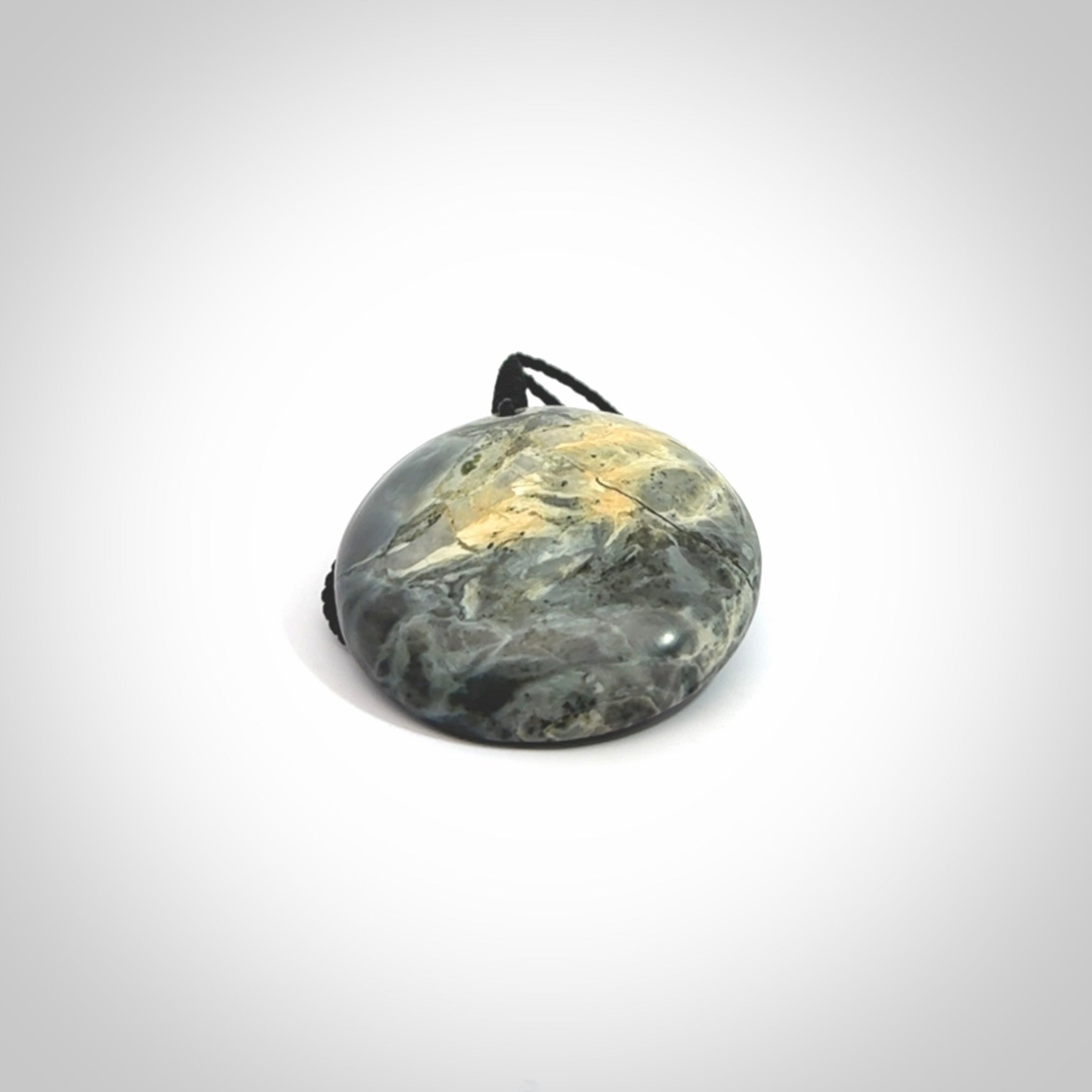 This cupped disc pendant, is carved from a very striking New Zealand Nelson jade.