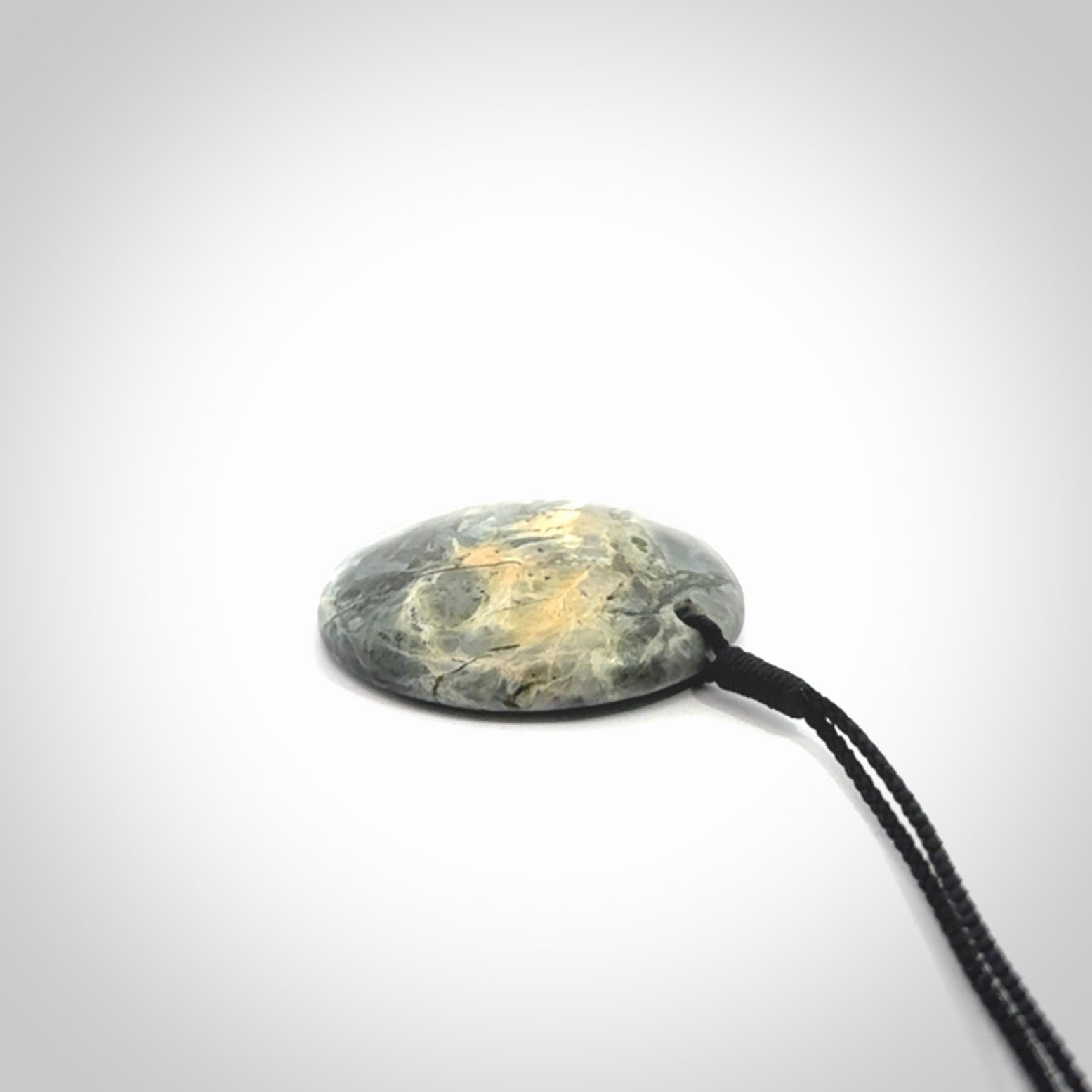 This cupped disc pendant, is carved from a very striking New Zealand Nelson jade.