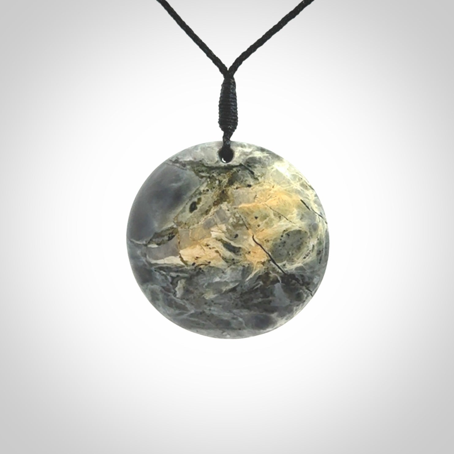This cupped disc pendant, is carved from a very striking New Zealand Nelson jade.