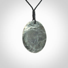 This cupped disc pendant, is carved from a very striking New Zealand Nelson jade.
