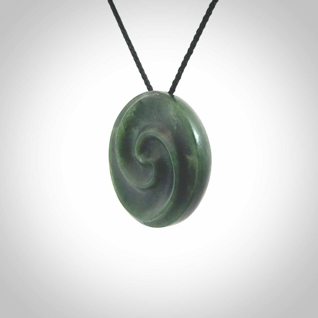 This pendant is a medium sized double koru necklace carved from a New Zealand Jade with Mother of Pearl inlay. Kyohei Noguchi carved this piece for us so the workmanship is outstanding. Handmade in New Zealand, a beautiful piece of jade jewellery.