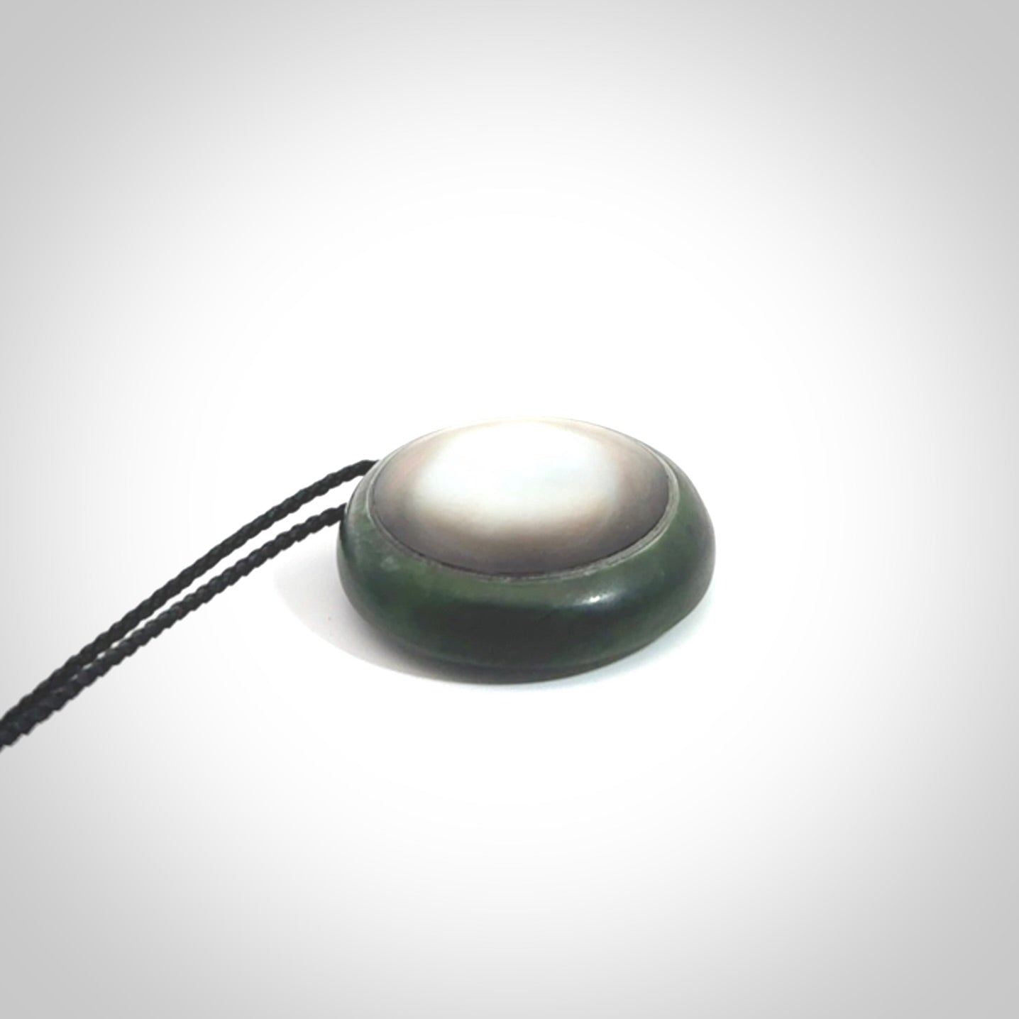 This pendant is a medium sized double koru necklace carved from a New Zealand Jade with Mother of Pearl inlay. Kyohei Noguchi carved this piece for us so the workmanship is outstanding. Handmade in New Zealand, a beautiful piece of jade jewellery.