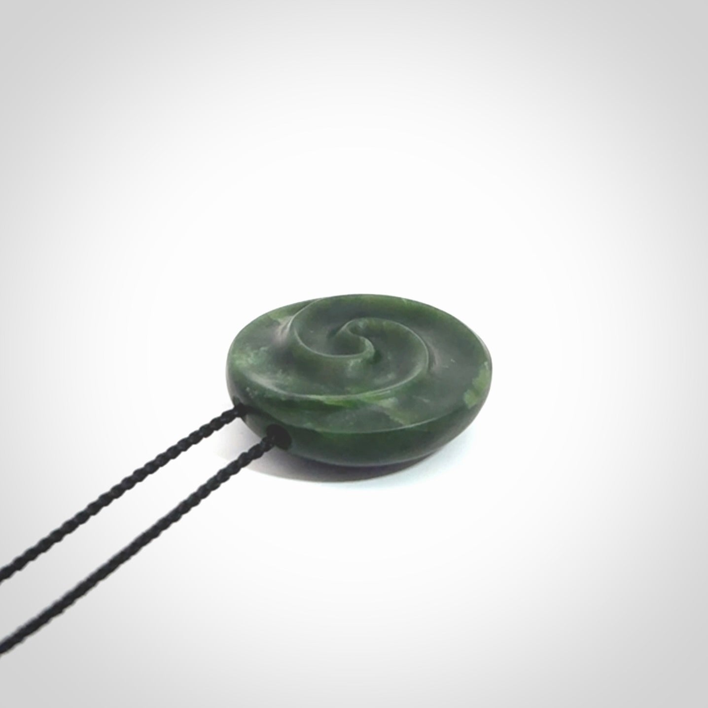 This pendant is a medium sized double koru necklace carved from a New Zealand Jade with Mother of Pearl inlay. Kyohei Noguchi carved this piece for us so the workmanship is outstanding. Handmade in New Zealand, a beautiful piece of jade jewellery.
