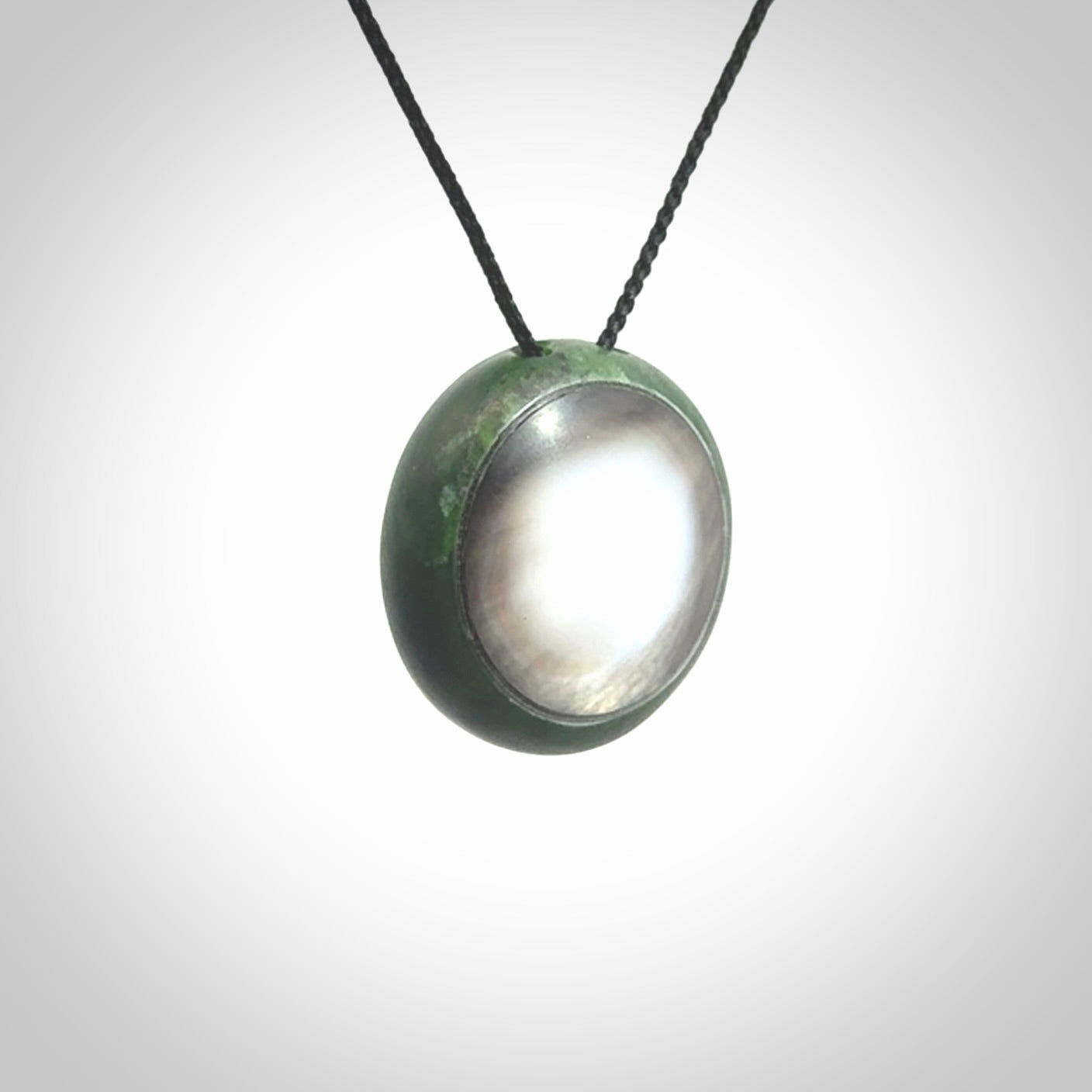 This pendant is a medium sized double koru necklace carved from a New Zealand Jade with Mother of Pearl inlay. Kyohei Noguchi carved this piece for us so the workmanship is outstanding. Handmade in New Zealand, a beautiful piece of jade jewellery.