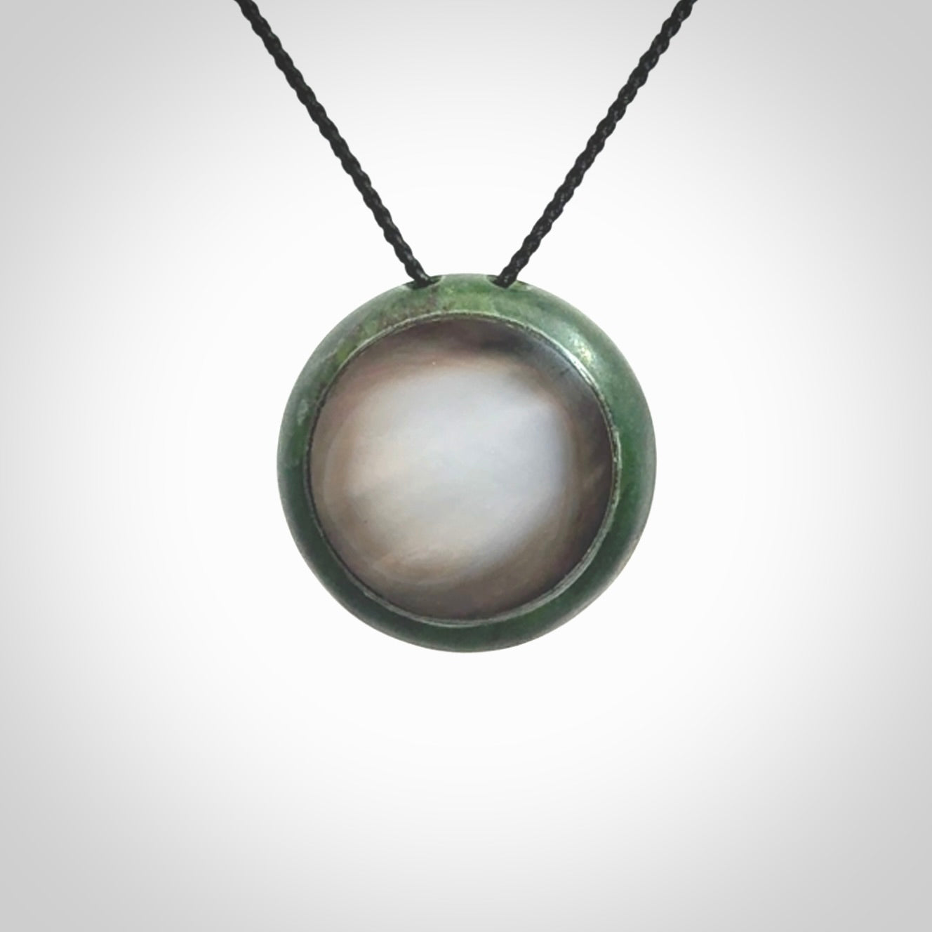 This pendant is a medium sized double koru necklace carved from a New Zealand Jade with Mother of Pearl inlay. Kyohei Noguchi carved this piece for us so the workmanship is outstanding. Handmade in New Zealand, a beautiful piece of jade jewellery.