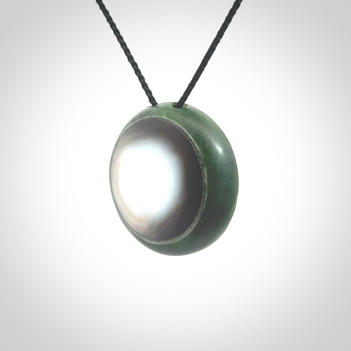 This pendant is a medium sized double koru necklace carved from a New Zealand Jade with Mother of Pearl inlay. Kyohei Noguchi carved this piece for us so the workmanship is outstanding. Handmade in New Zealand, a beautiful piece of jade jewellery.